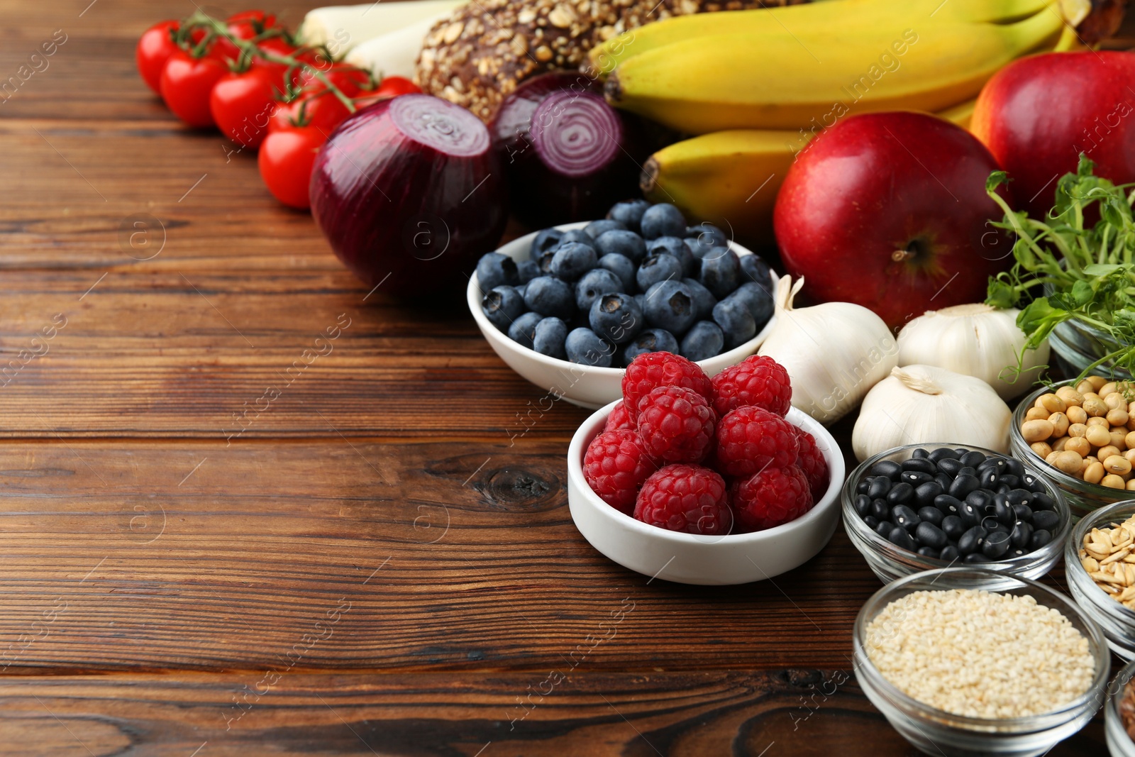 Photo of Different fresh products on wooden table, space for text. Source of prebiotics