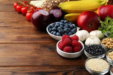 Different fresh products on wooden table, space for text. Source of prebiotics