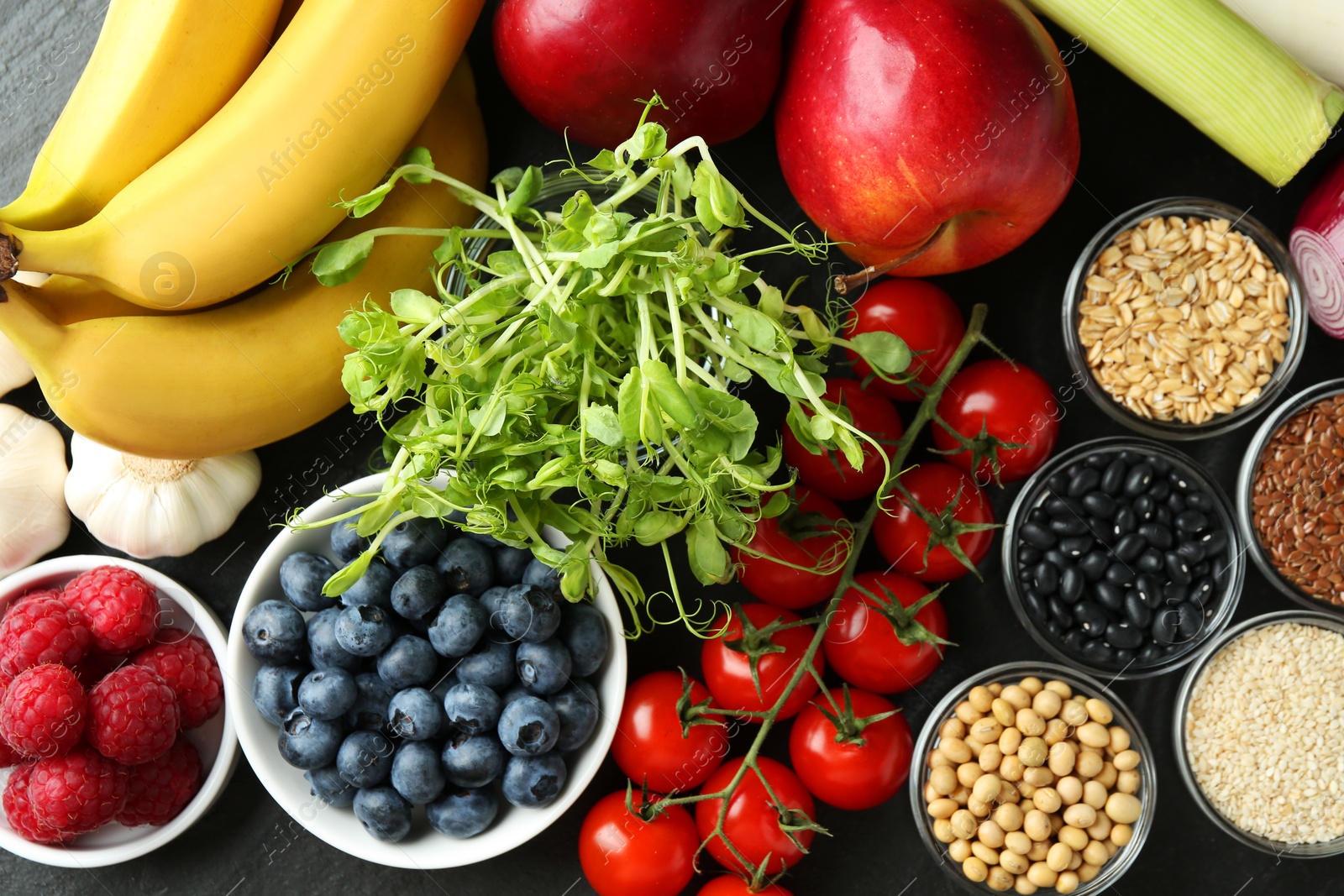 Photo of Different fresh products on black table, flat lay. Source of prebiotics