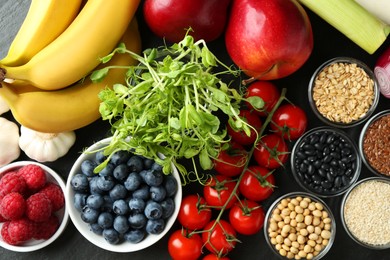 Different fresh products on black table, flat lay. Source of prebiotics