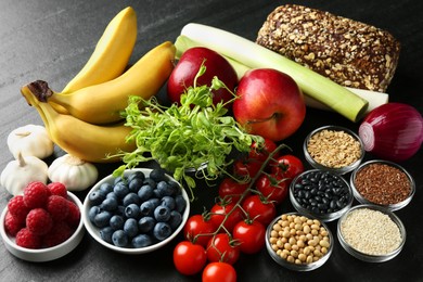 Photo of Different fresh products on black table. Source of prebiotics