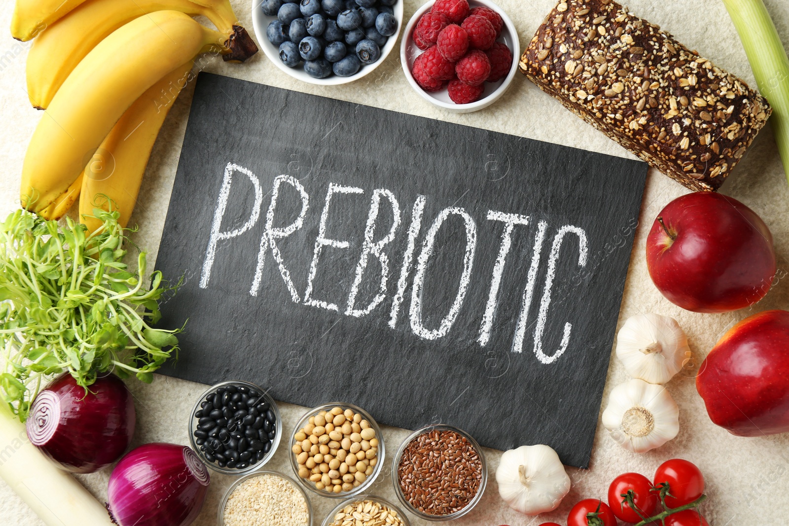 Photo of Slate board with word Prebiotic and different fresh products on grey table, flat lay