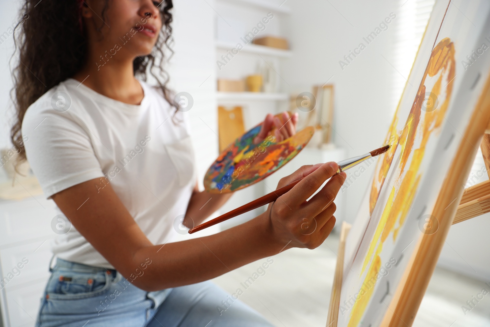 Photo of Woman drawing picture with paint in studio, closeup