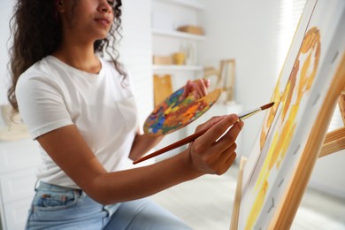 Photo of Woman drawing picture with paint in studio, closeup