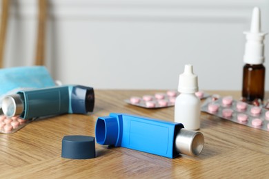 Photo of Different asthma medications on wooden table, closeup