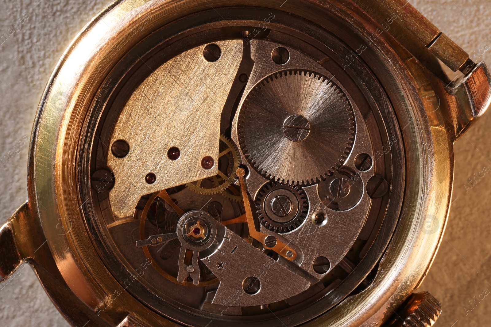 Photo of Mechanism of vintage wrist watch on beige background, top view