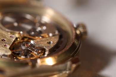 Photo of Mechanism of vintage wrist watch on light background, closeup