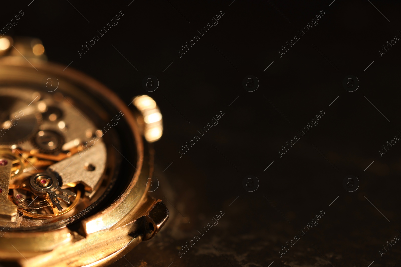 Photo of Mechanism of vintage wrist watch on black background, closeup. Space for text