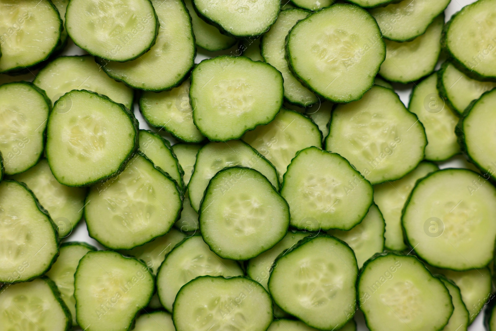 Photo of Slices of fresh cucumbers as background, top view