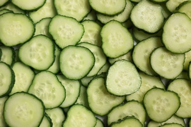 Photo of Slices of fresh cucumbers as background, top view