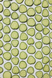 Slices of fresh cucumbers on white background, flat lay