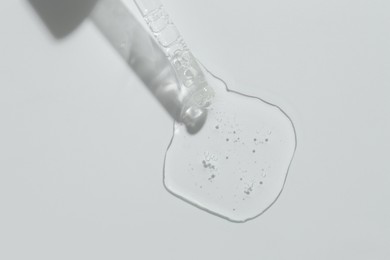 Photo of Pipette with cosmetic serum on light background, top view