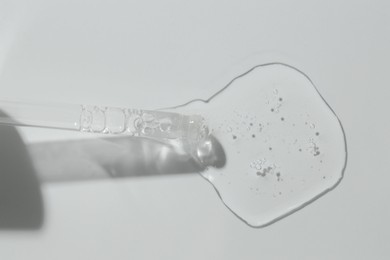 Photo of Pipette with cosmetic serum on light background, top view