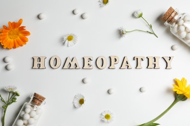 Photo of Word Homeopathy, pills and medicinal herbs on white background, flat lay