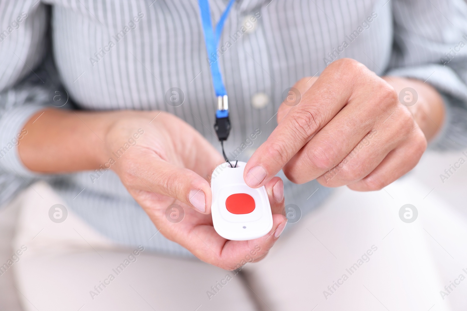 Photo of Senior woman pressing emergency call button at home, closeup