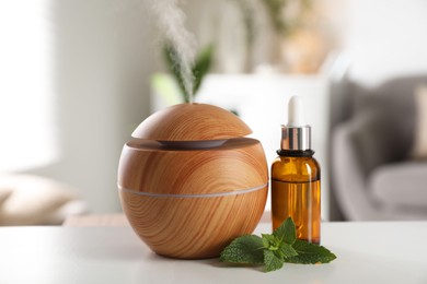 Photo of Essential oil diffuser, cosmetic product and mint on white table at home