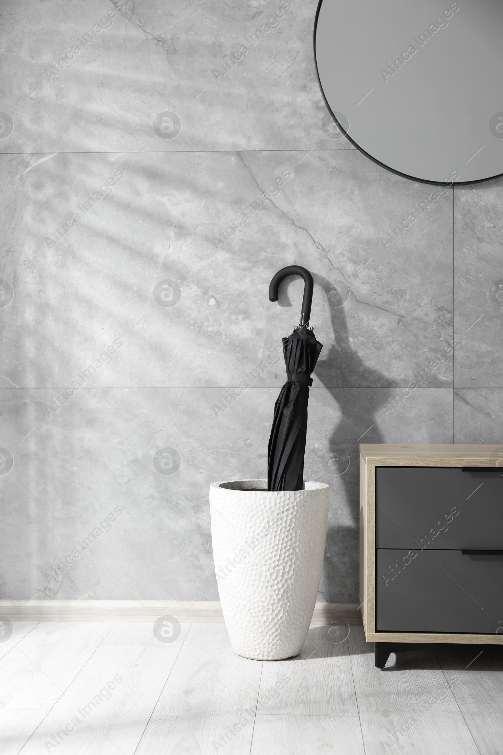 Photo of Holder with black umbrella and cabinet indoors