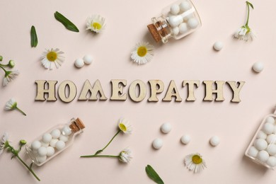 Word Homeopathy, pills and chamomiles on beige background, flat lay