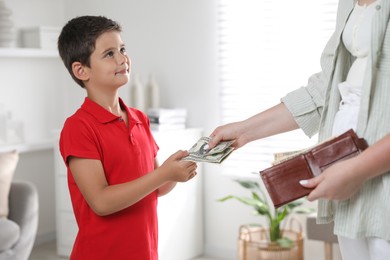 Mother giving pocket money to her son at home