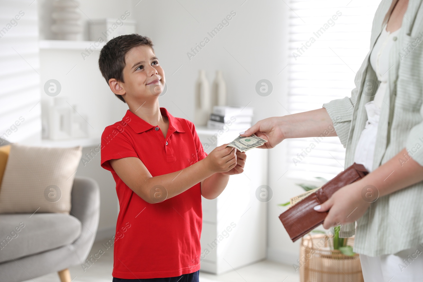 Photo of Mother giving pocket money to her son at home