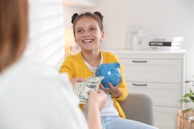 Mother giving pocket money to her daughter at home