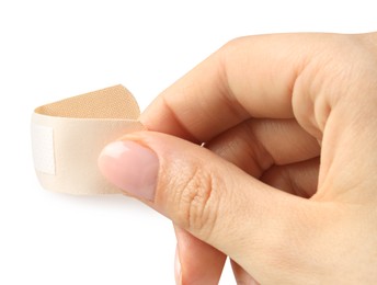 Photo of Woman putting medical adhesive bandage on white background, closeup