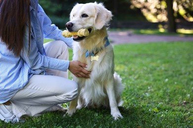 Owner with cute Golden Retriever dog outdoors, closeup. Space for text