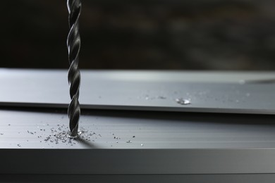 Photo of Drilling hole in plank on table against gray background, closeup