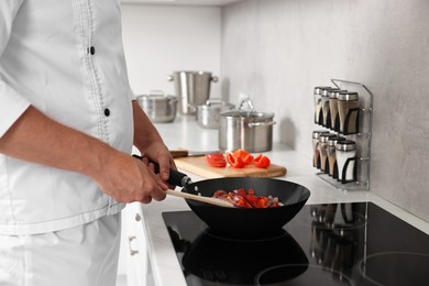 Professional chef cooking delicious food on stove in kitchen, closeup