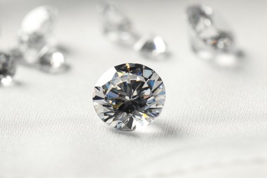 One beautiful shiny diamond on white fabric, closeup