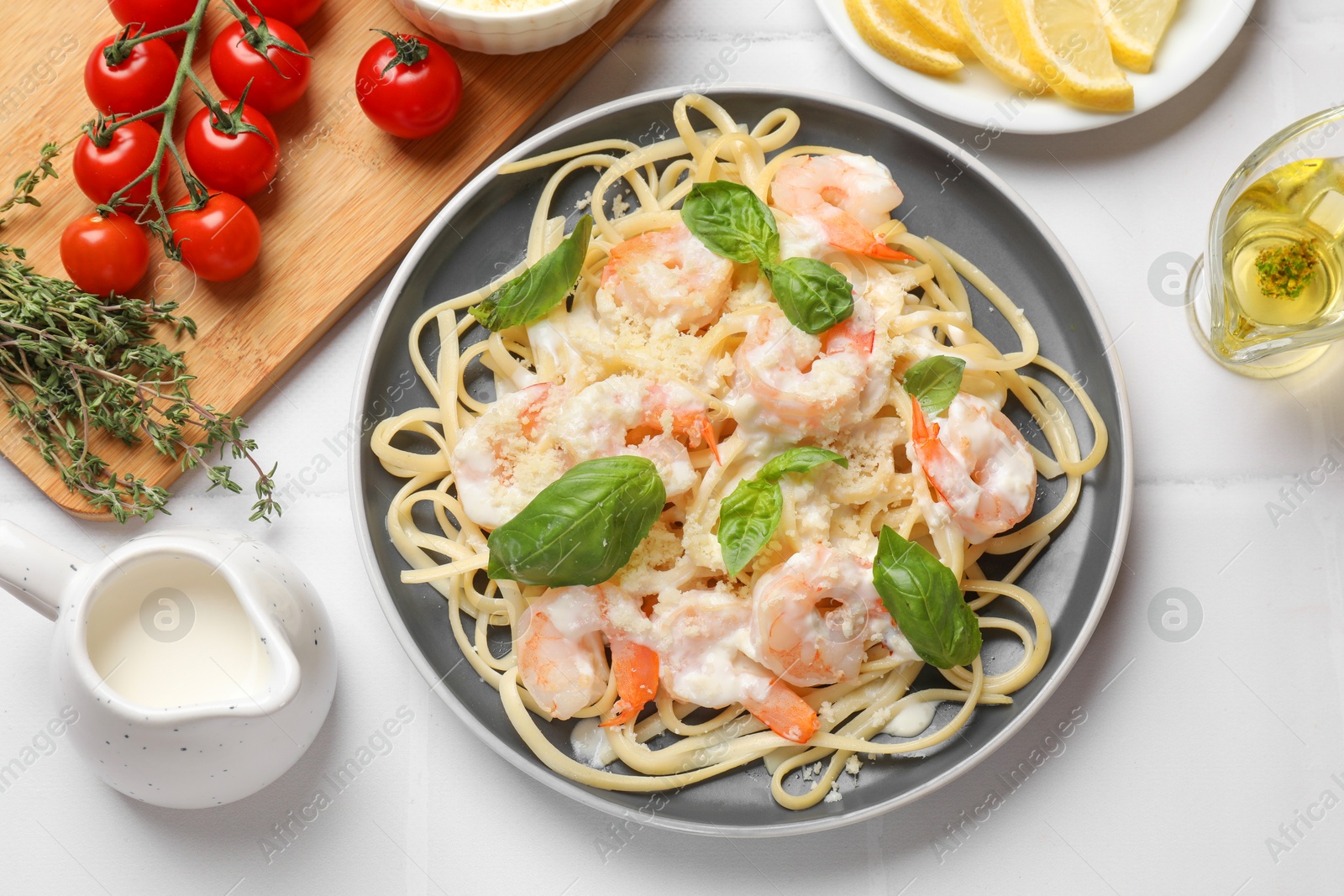 Photo of Tasty pasta with shrimps served on white table, flat lay