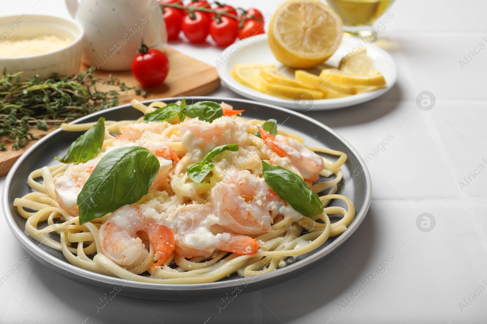 Photo of Tasty pasta with shrimps served on white table, closeup