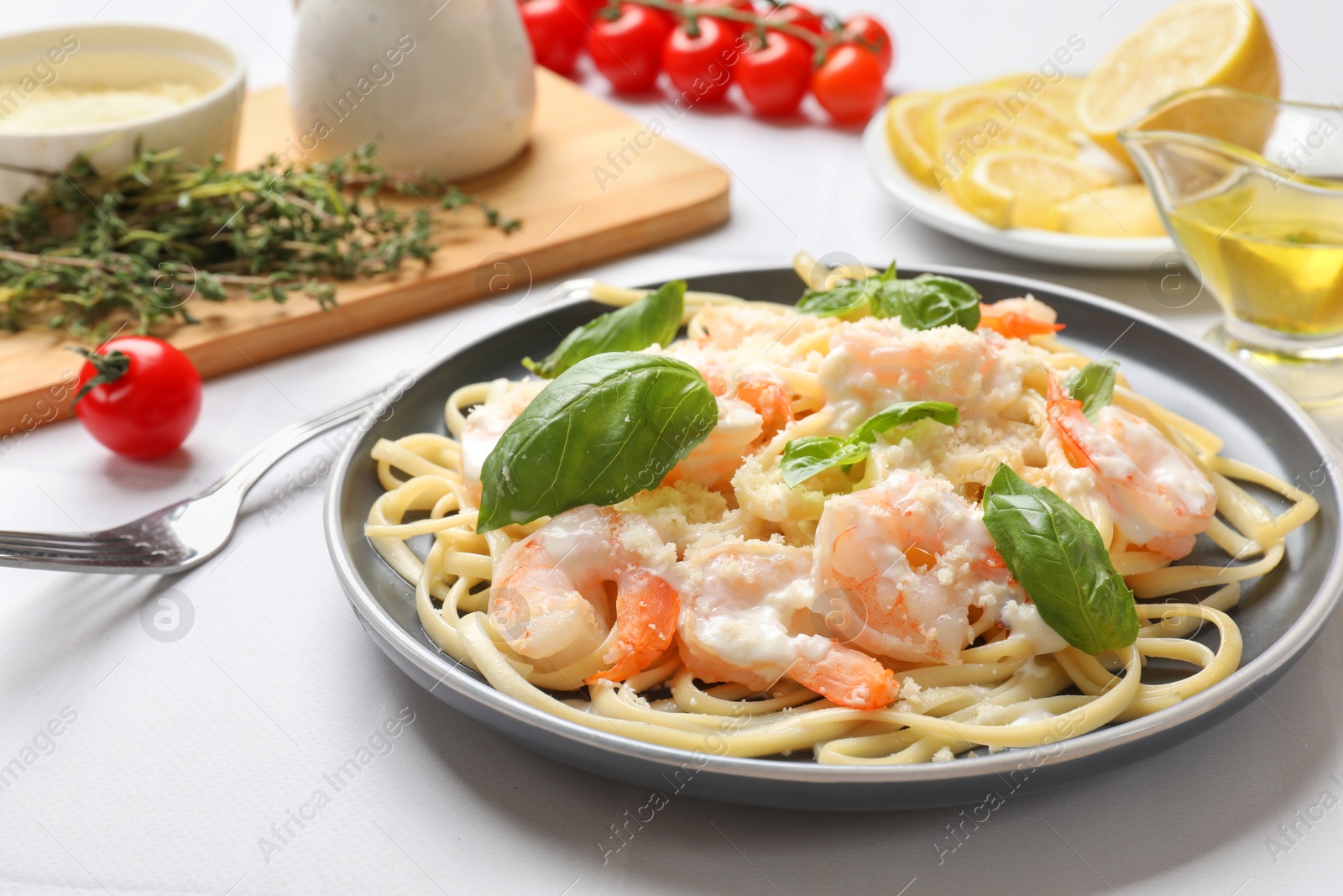 Photo of Tasty pasta with shrimps served on white table, closeup