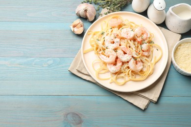 Photo of Delicious pasta with shrimps served on blue wooden table, flat lay. Space for text