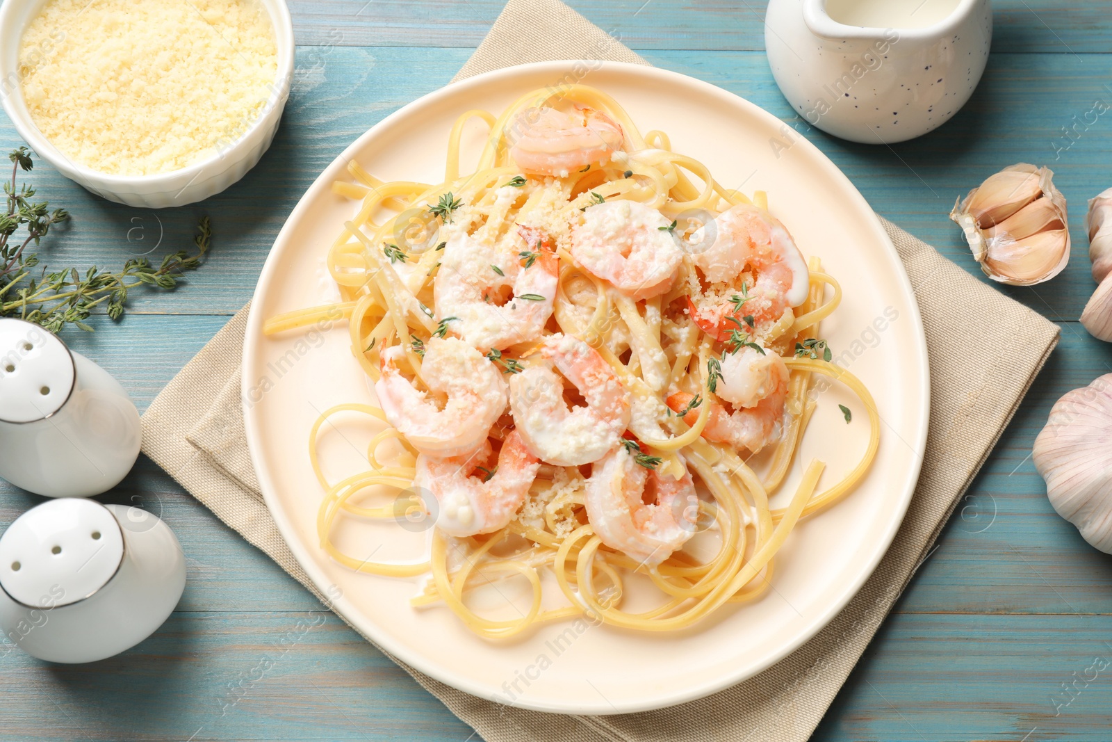 Photo of Delicious pasta with shrimps served on blue wooden table, flat lay