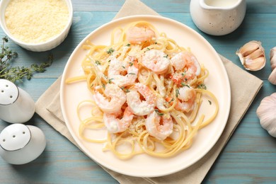 Photo of Delicious pasta with shrimps served on blue wooden table, flat lay