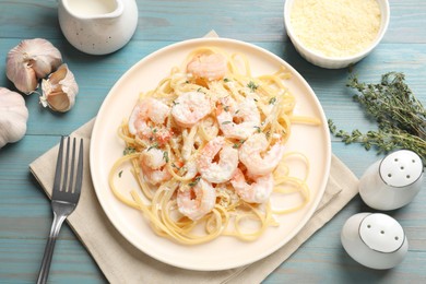 Photo of Delicious pasta with shrimps served on blue wooden table, flat lay