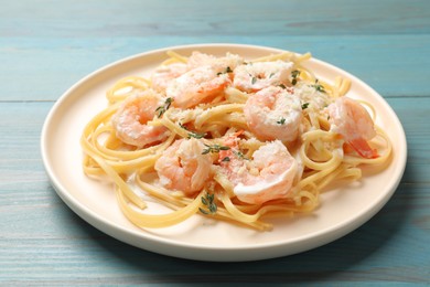 Photo of Delicious pasta with shrimps on blue wooden table, closeup