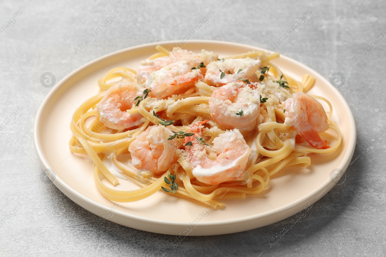 Photo of Delicious pasta with shrimps on grey table, closeup