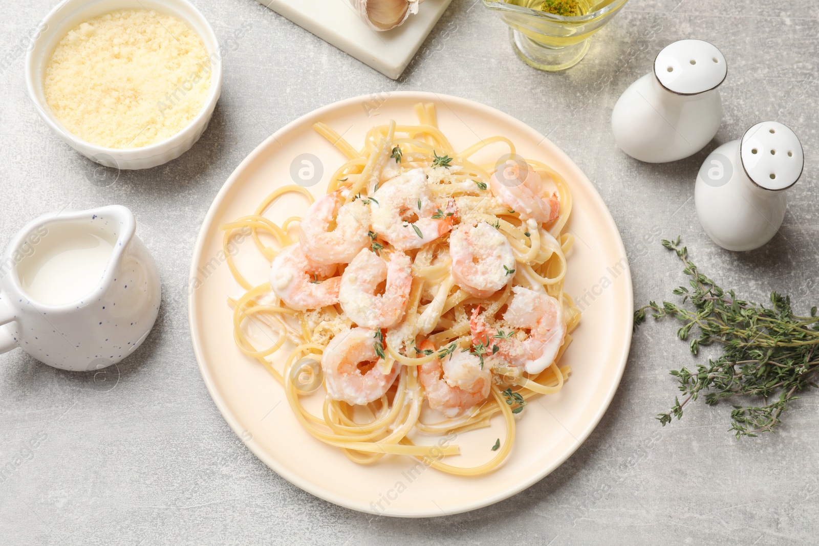 Photo of Delicious pasta with shrimps served on grey table, flat lay