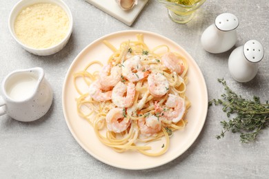 Photo of Delicious pasta with shrimps served on grey table, flat lay