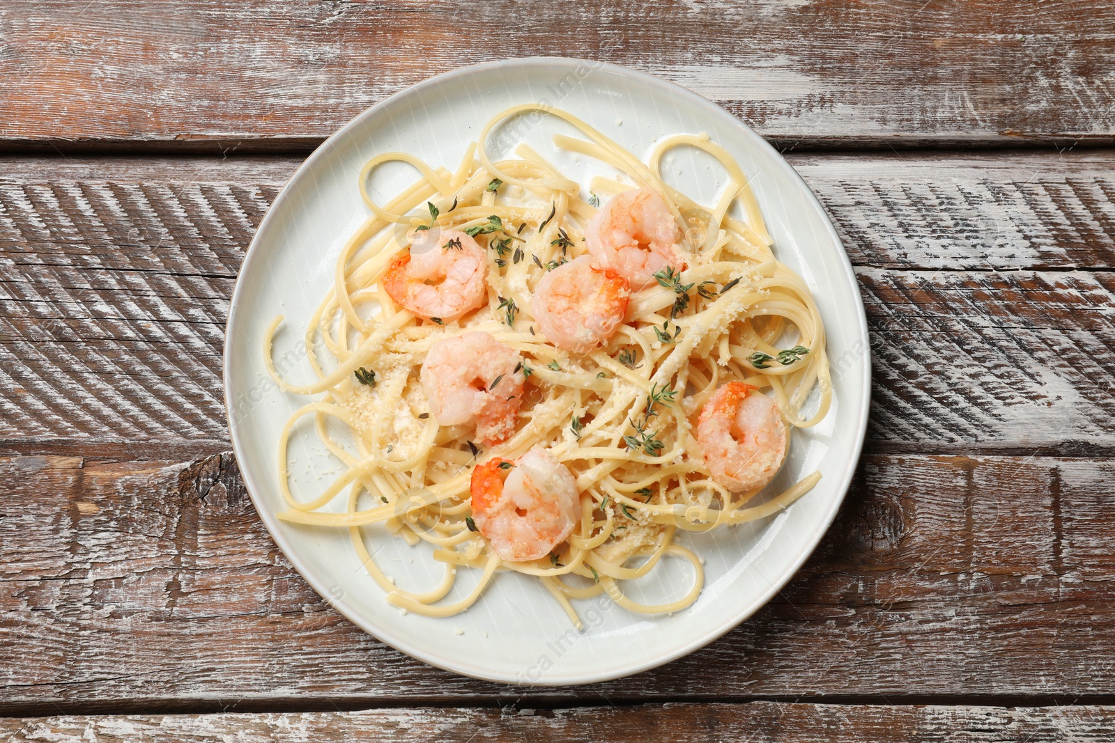 Photo of Delicious pasta with shrimps on wooden table, top view