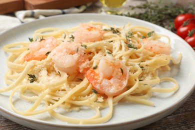 Photo of Delicious pasta with shrimps on wooden table, closeup