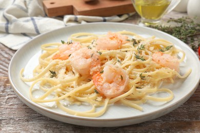 Photo of Delicious pasta with shrimps on wooden table, closeup