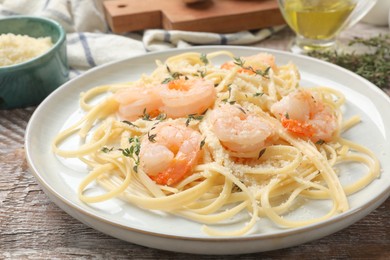 Photo of Delicious pasta with shrimps on wooden table, closeup