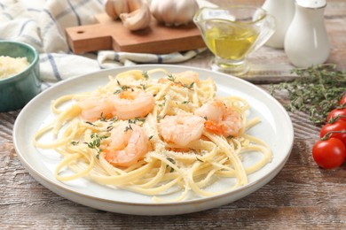 Photo of Delicious pasta with shrimps and products on wooden table, closeup