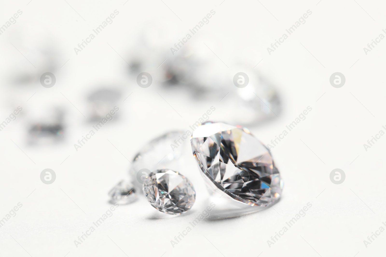 Photo of Many beautiful shiny diamonds on white background, closeup