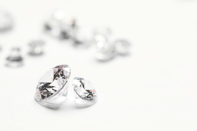 Photo of Many beautiful shiny diamonds on white background, closeup. Space for text