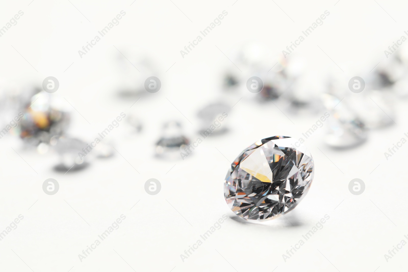 Photo of Many beautiful shiny diamonds on white background, closeup. Space for text