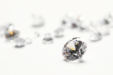 Many beautiful shiny diamonds on white background, closeup. Space for text